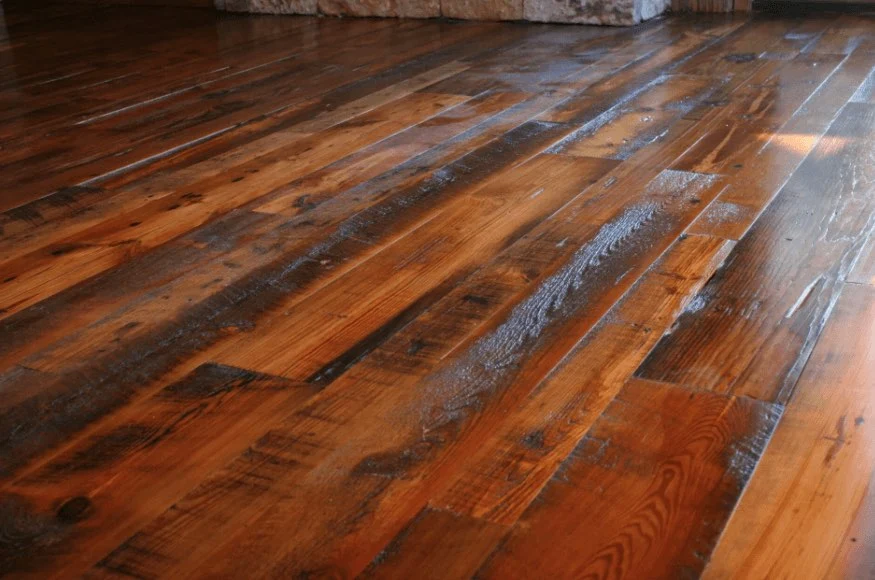 Reclaimed rustic wood flooring with saw marks, knots, and color variation